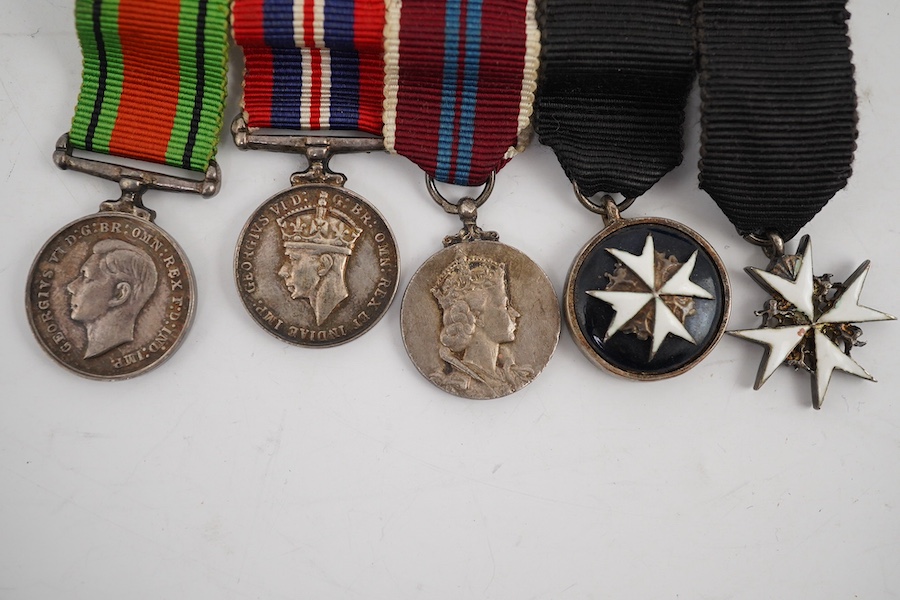 A WWII and later medal group of five medals, together with its miniature set, comprising; The Defence Medal, the 1939-1945 medal, the ERII Coronation medal, and two St. John’s Ambulance Service medals. Condition - fair t